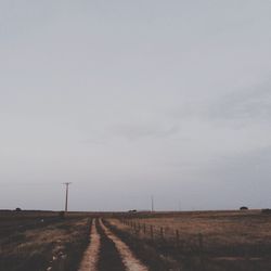 Road amidst field against sky