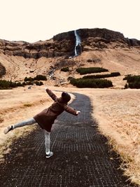 Rear view of man on landscape against clear sky