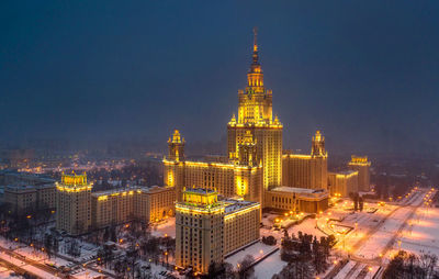 Illuminated buildings in city against sky