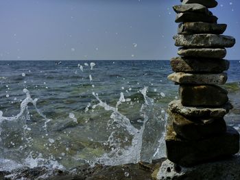 Stack of rocks on beach against clear sky