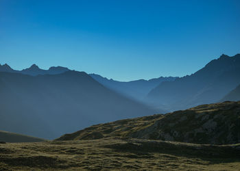 Scenic view of mountains against clear blue sky