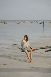 Full length of woman on beach against sky