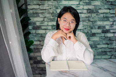 Handsome young smiling businesswoman working at office with laptop on desk