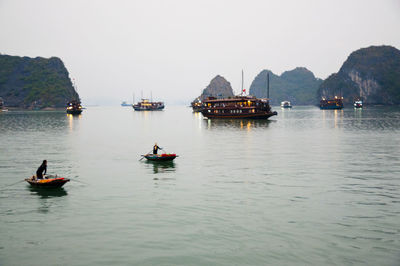 Boats sailing on river against sky