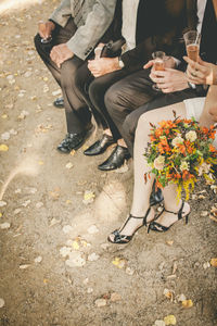 Low section of guests having drinks during wedding ceremony