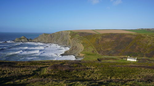 Scenic view of beach against clear blue sky