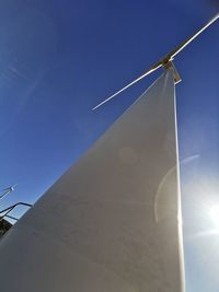 Low angle view of windmill against blue sky