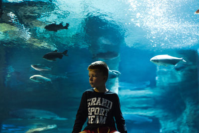 Boy looking at fish in aquarium