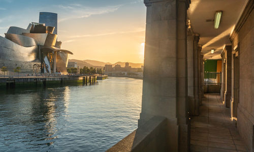 Buildings at waterfront during sunset