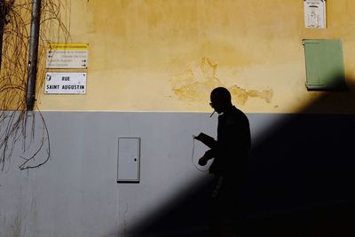 Man standing by text on wall