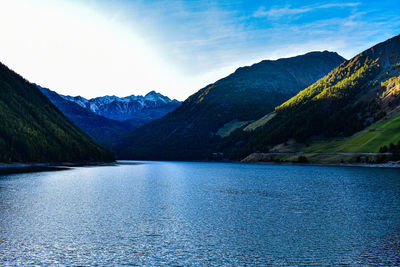 Scenic view of lake by mountains against sky