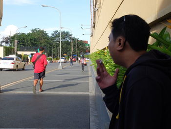 People walking on street in city against clear sky