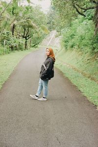 Rear view of woman walking on road