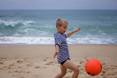 Rear view of girl playing at beach