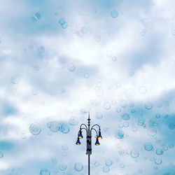 Low angle view of illuminated lighting equipment against blue sky