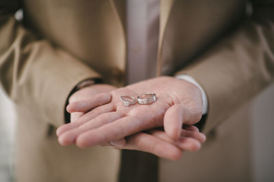 Midsection of bride holding wedding rings