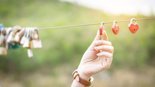 Close-up of hand holding love lock on rope