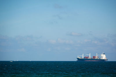 Ship sailing on sea against sky