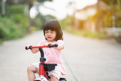 Cute girl riding bicycle on road