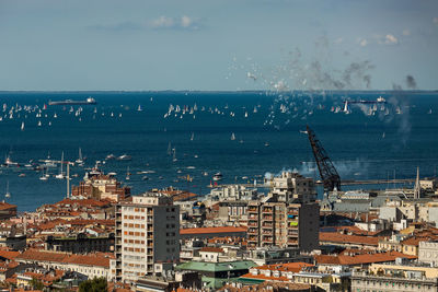 High angle view of cityscape by sea against sky