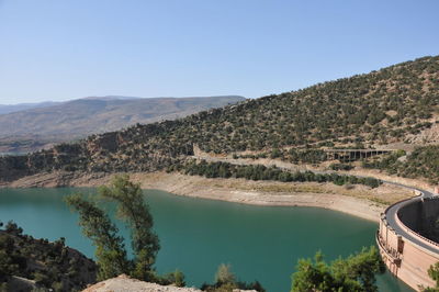 Scenic view of lake and mountains against clear blue sky