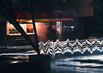 Bridge over river against illuminated building