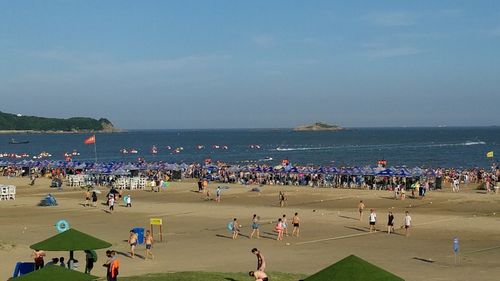 People at beach against sky
