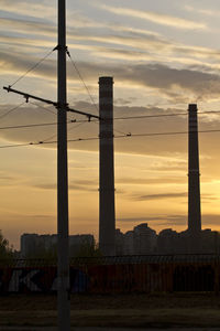 View of factory against cloudy sky during sunset