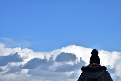 Rear view of woman against blue sky