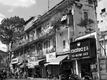 People on street against buildings in city