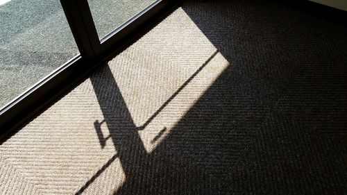 High angle view of shadow on tiled floor