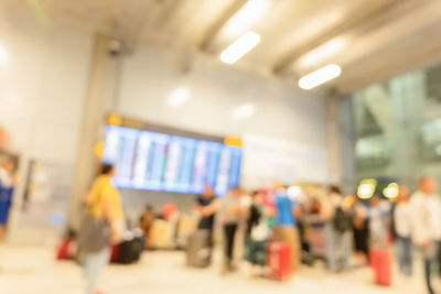 Defocused image of people walking in illuminated corridor