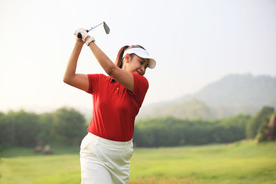 Midsection of man playing guitar on golf course