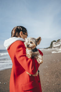 Young woman with yorkshire terrier at beach