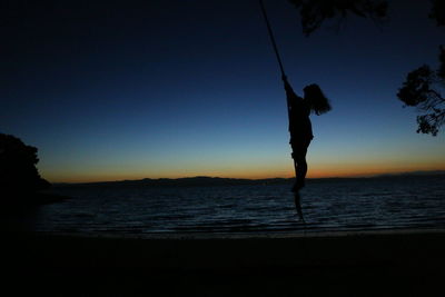 Silhouette of man in sea against sky
