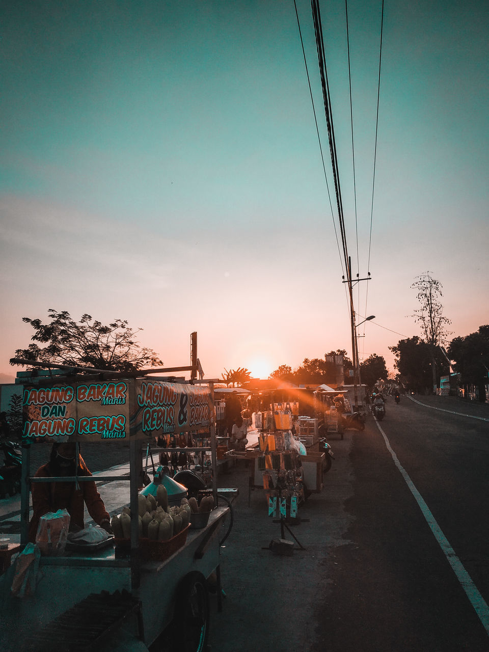 sky, evening, dusk, sunset, transportation, nature, light, night, city, architecture, mode of transportation, street, road, tree, group of people, reflection, outdoors, water, travel destinations, cloud, built structure, cityscape, travel, car