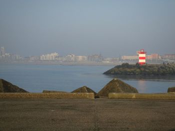 Scenic view of sea by buildings against sky