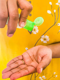 Close-up of hands holding yellow flower