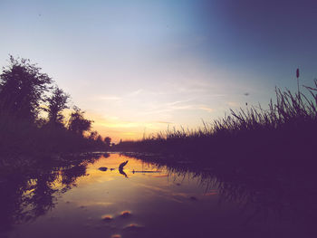 Scenic view of lake against sky during sunset