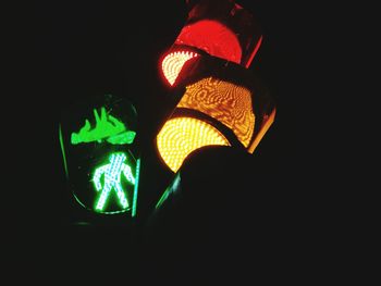 Low angle view of illuminated lighting equipment against black background