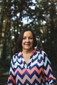 Portrait of smiling mid adult woman in forest