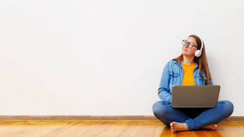 Young woman using laptop while sitting on table