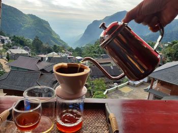 Man preparing food on table against mountains