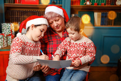 Grandmother embracing her grandchildren at home. happy holidays