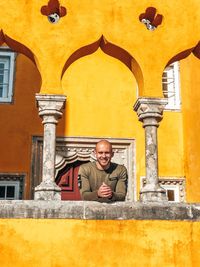 Portrait of smiling man standing against building