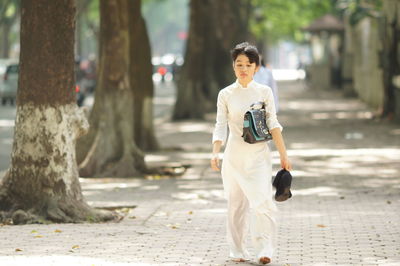 Portrait of teenage girl walking on footpath