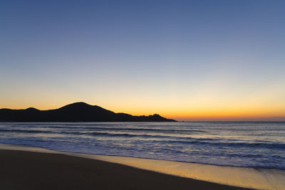 Scenic view of sea against clear sky during sunset