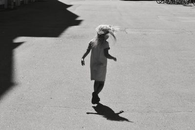 Rear view of girl walking on street in city