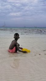 Boy toy on beach against sky