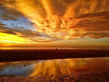 Scenic view of beach against dramatic sky